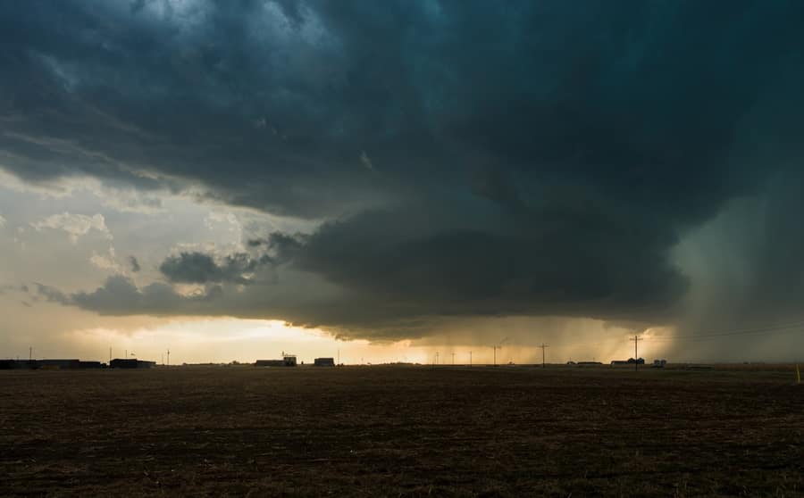 A dark storm shelf cloud advancing over flat farmland